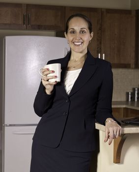 Business woman drinks coffee in the kitchen