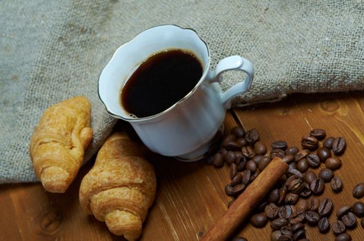 Coffee cup with cinnamon and coffee beans background