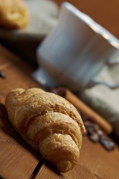 Coffee cup with cinnamon and croissant ,coffee beans background