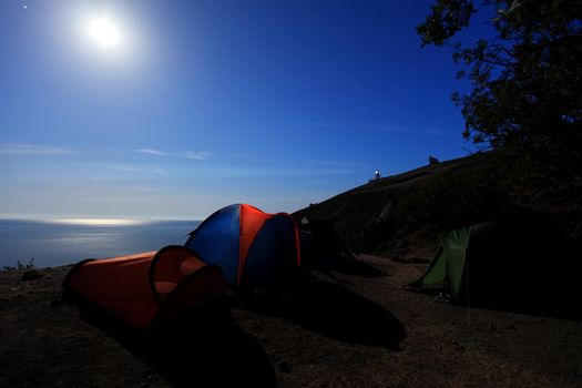 Tourist tent at the seaside. Moon Night. Mountain Meganom, Crimea, Ukraine
