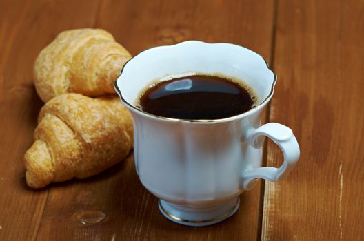 Coffee cup with cinnamon and croissant ,coffee beans background