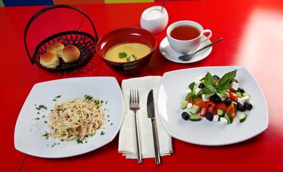 european food style.lunch greek salad , spaghetti and tea with bun