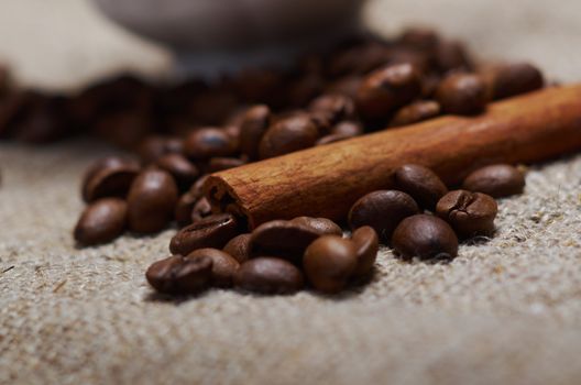 Coffee cup with cinnamon and coffee beans background