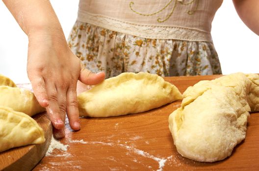 Smiling little girl kneading dough at kitchen .Detail of hands kneading dough