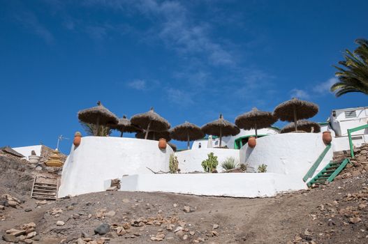 white colored houses with umbrella on top of the mountain