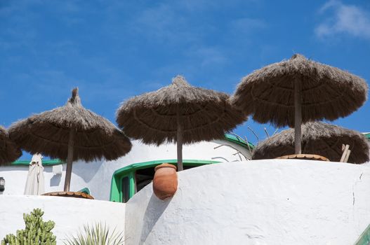 white colored houses with umbrella on top of the mountain