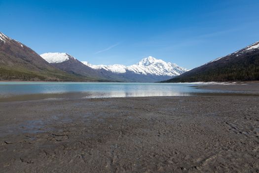 A large blue lake begins to melt on a hot spring day