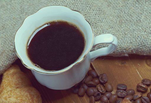 Coffee cup with cinnamon and coffee beans background