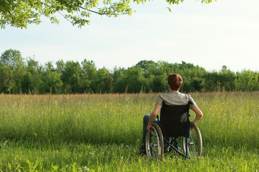 Young man in a wheelchair enjoying fresh air on a sunny day