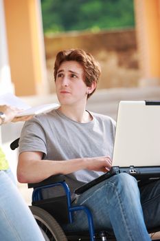 Young disabled boy and his female friend studying together