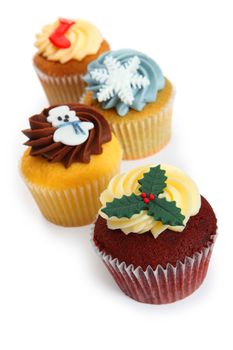 Photo of four cupcakes decorated for Christmas. Focus on first cupcake.
