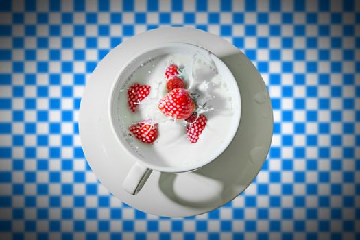 cup with milk and strawberry splash on blue white background