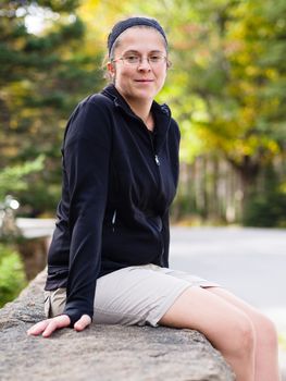 Woman resting by a countryside road in Acadia National Park