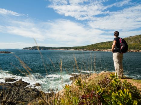 Woman standing on a rock cliff by the atlantic ocean