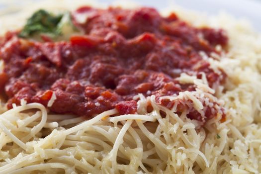 Close up  of spaghetti topped with tomato sauce and grated cheese