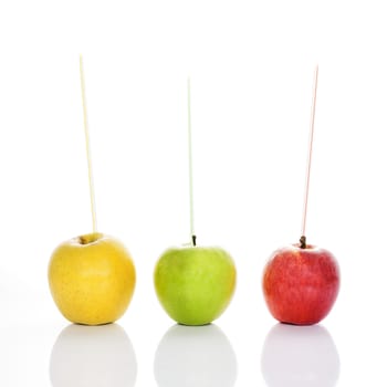 red, yellow and green apples with straws