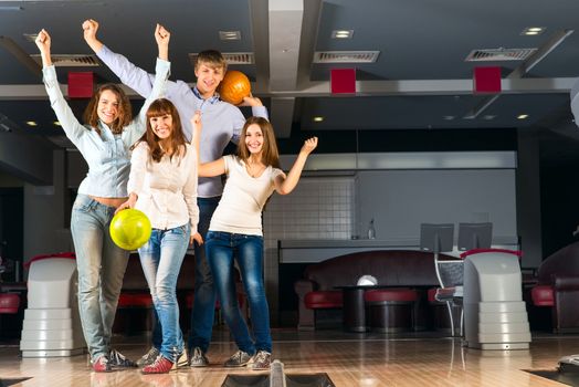 Group of young friends playing bowling, spending time with friends