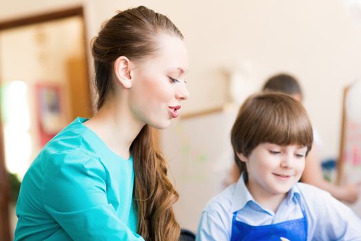 teacher deals with a boy, a drawing lesson