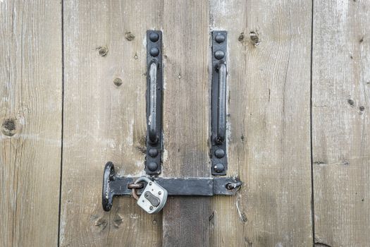 wooden gate with locked, rusty metal padlock