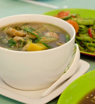  a savoury thick soup made from pork , spices and vegetables in white bowl