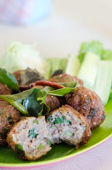 close up meatballs with fried  bergamot leaves and fresh vegetable