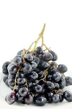 black  grapes  fruits on white plate over white background