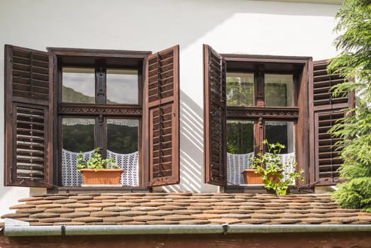 traditional wooden windows with opened wooden blinds