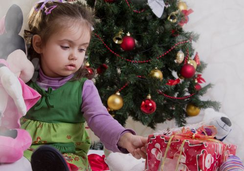 Girl under Christmas tree with gifts