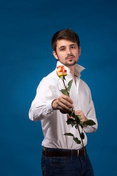 Man giving the red roses, on blue background