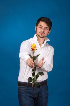 Man giving the red roses, on blue background