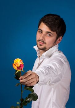 Man giving the red roses, on blue background