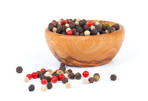 Colored Pepper in the wooden bowl, on the white background