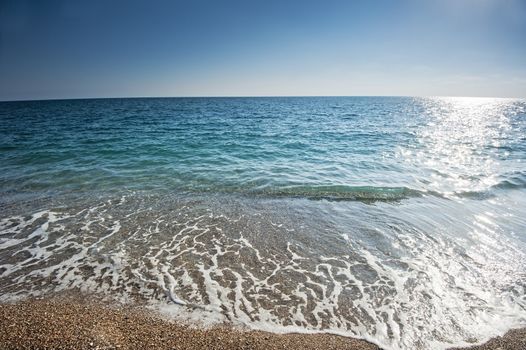 Splash of sea foam on a sandy beach