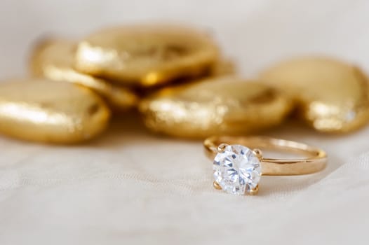 wedding favors and wedding ring on on colored background