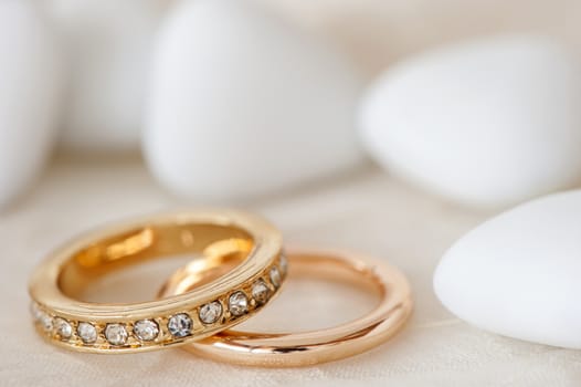 wedding favors and wedding ring on on colored background