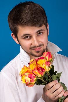 young man giving a red rose, on blue background