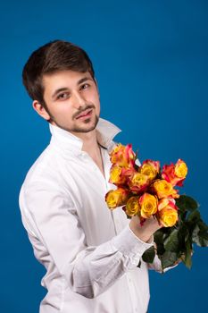 young man giving a red rose, on blue background