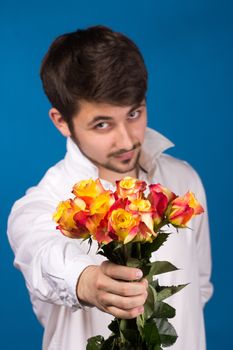 young man giving a red rose, on blue background