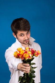 young man giving a red rose, on blue background