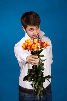 young man giving a red rose, on blue background