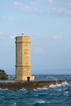 Old lighthouse at the entrance of a harbor
