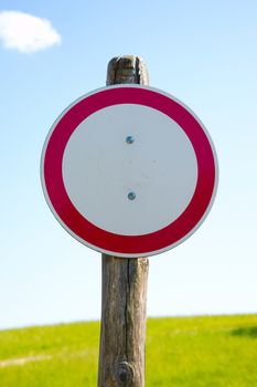 No entry sign in front of a green field