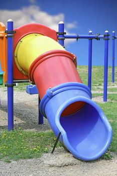 blue yellow and red plastic tube slide for children in the park