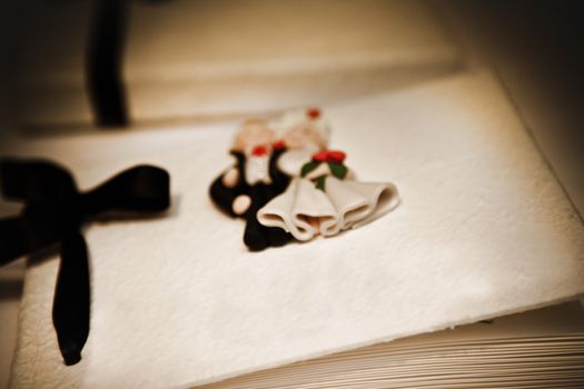 Guest book at a wedding ceremony decorated with a bride and groom and ornamental bow, shallow dof