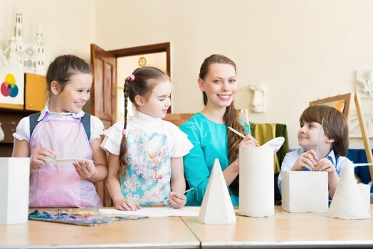 children draw with the teacher in the classroom drawing