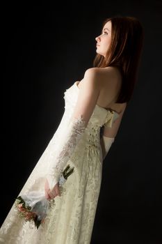 young attractive girl in a wedding dress on a black background