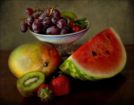 still life in chiaroscuro; a tray with grapes, mango, strawberries, kiwi and watermelon