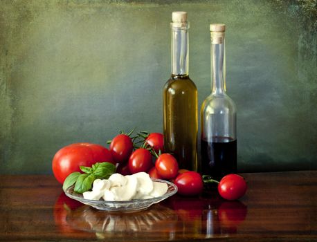 Healthy and simple salad based on absolute fresh ingredients: red ripe tomatoes, mozzarella, basil, olive oil and if you like some drops of balsamic vinegar