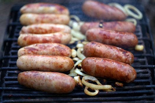 A lot of bratwurst sausages on grill.