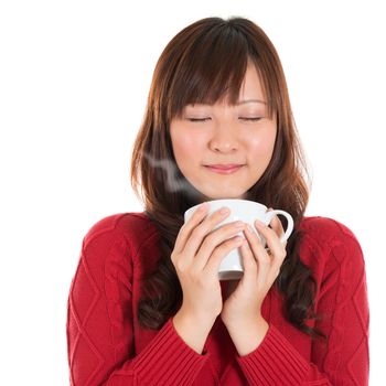 Asian girl enjoying a cup of coffee, with coffee smoke, isolated on white background. Beautiful mixed Asian model.